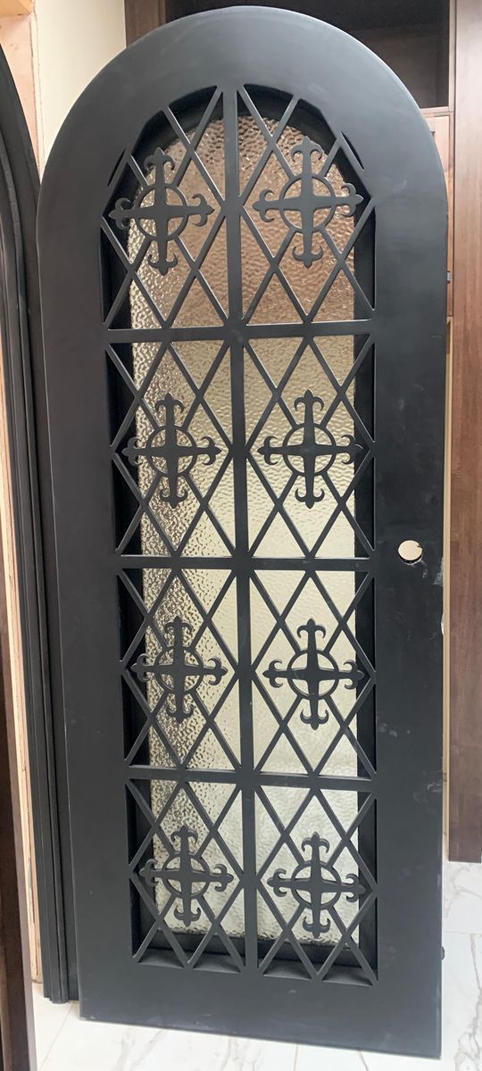 Round-top iron wine cellar door with diamond grille and cross medallions